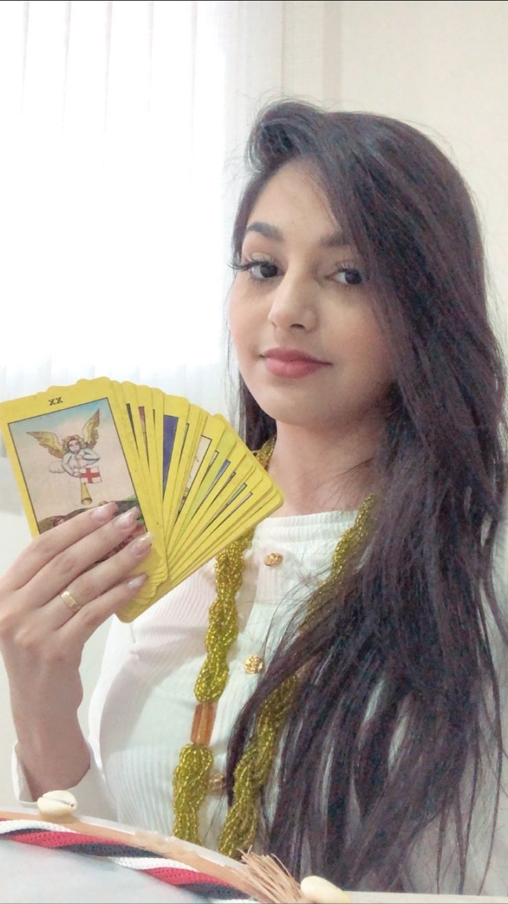 Jussara segurando cartas de tarot